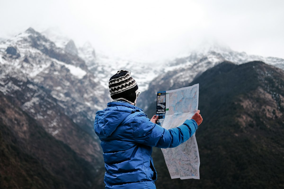 A traveler studying the landscape with a map